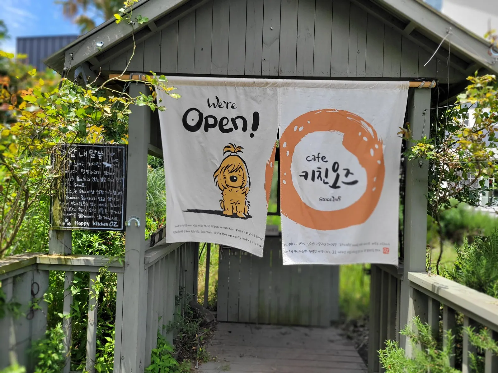 입구의 We’re Open 천과 키친오즈 로고