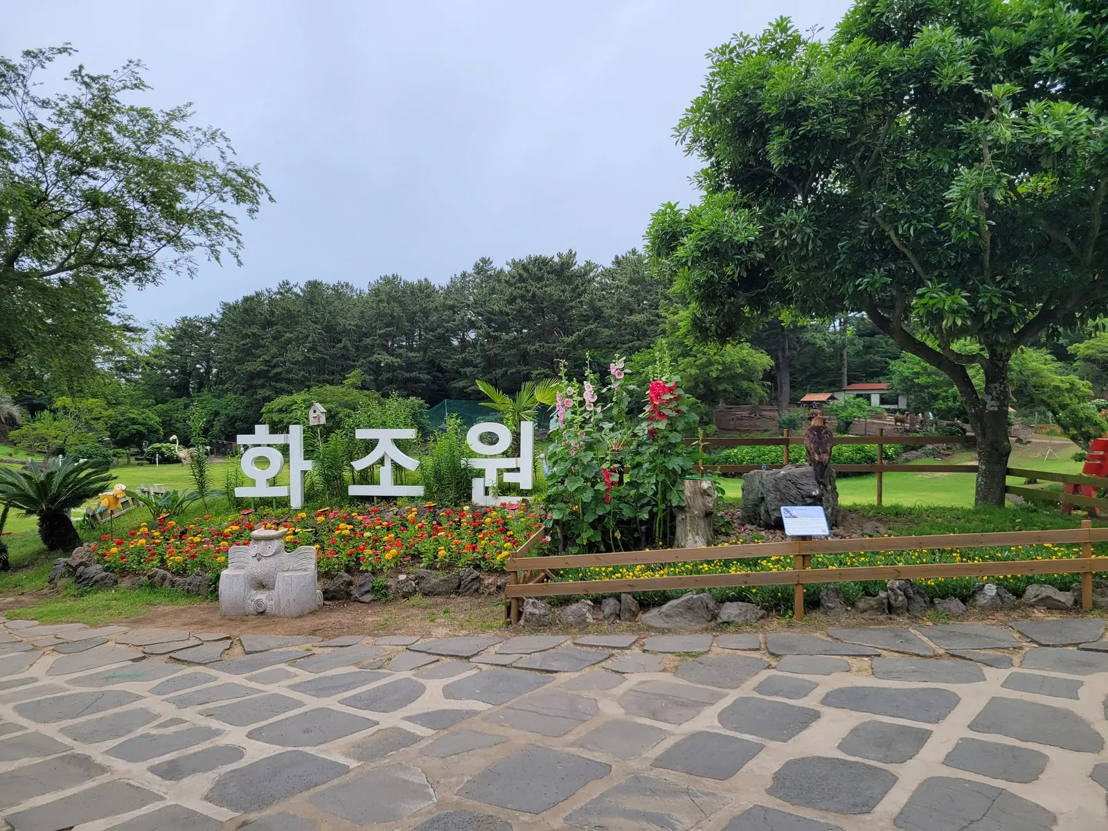 화조원 입구 사인과 잔디 정원