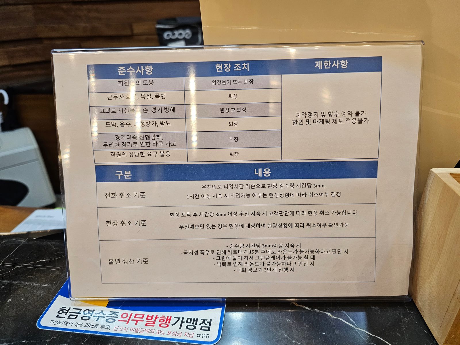 프런트에 놓인 준수사항과 우천 취소 기준 안내판